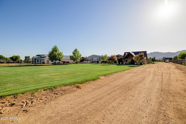 7738 N 185th Ave, Waddell, AZ 85355 - surrounding community with a lawn, fence, and a mountain view