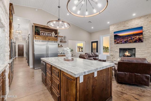 7738 N 185th Ave, Waddell, AZ 85355 - kitchen with open shelves, built in appliances, a fireplace, open floor plan, and light countertops