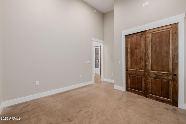 7738 N 185th Ave, Waddell, AZ 85355 - unfurnished bedroom featuring a high ceiling, concrete floors, and baseboards