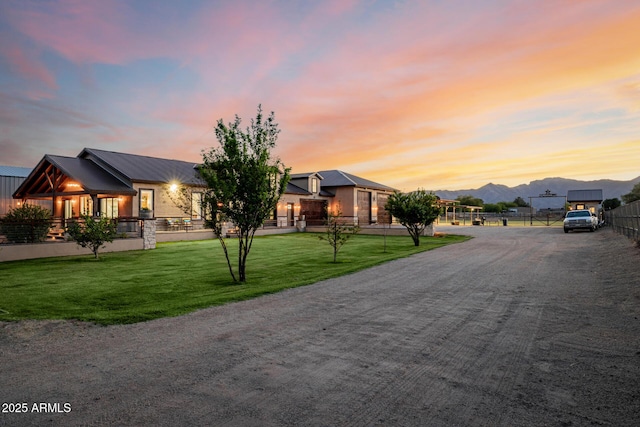 7738 N 185th Ave, Waddell, AZ 85355 - view of front of house featuring fence, a mountain view, a lawn, and metal roof
