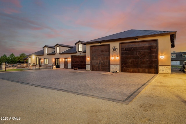 7738 N 185th Ave, Waddell, AZ 85355 - view of front of home featuring stone siding, a garage, stucco siding, decorative driveway, and metal roof