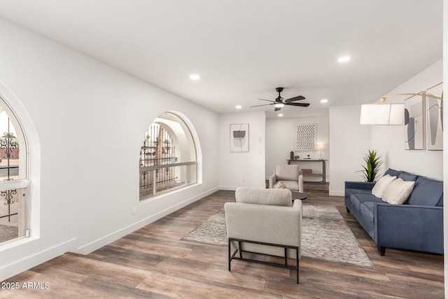 living room featuring ceiling fan and dark hardwood / wood-style flooring