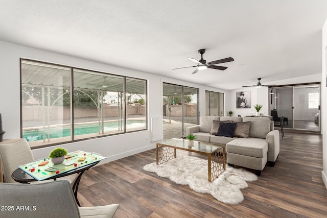 living room with ceiling fan and dark wood-type flooring