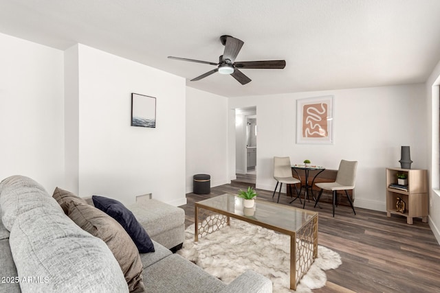 living room featuring ceiling fan and dark hardwood / wood-style floors