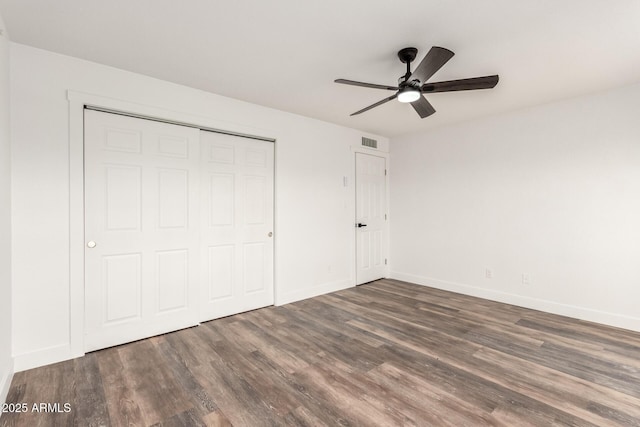 unfurnished bedroom featuring ceiling fan, a closet, and dark hardwood / wood-style floors