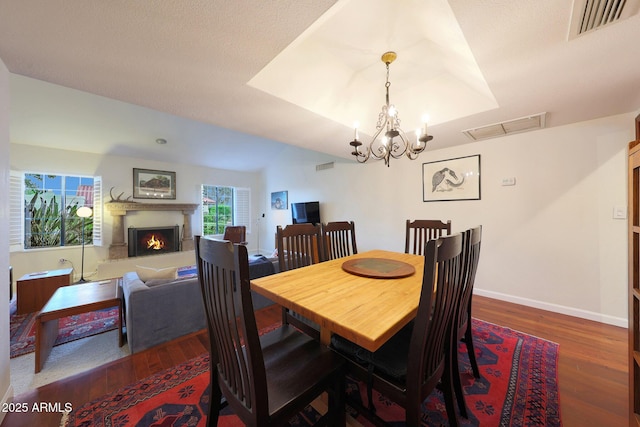 3417 E Mission Ln E, Phoenix, AZ 85028 - dining space with dark wood finished floors, a warm lit fireplace, baseboards, and a chandelier