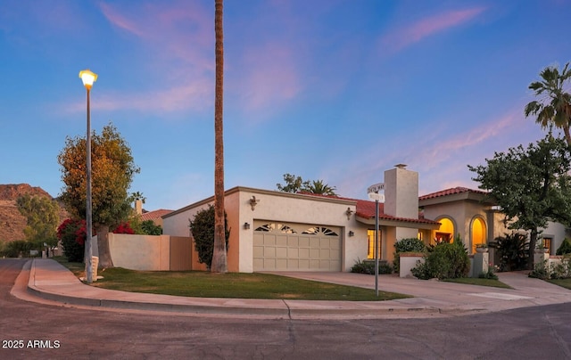 3417 E Mission Ln E, Phoenix, AZ 85028 - view of front of house featuring an attached garage, a chimney, driveway, stucco siding, and a tile roof