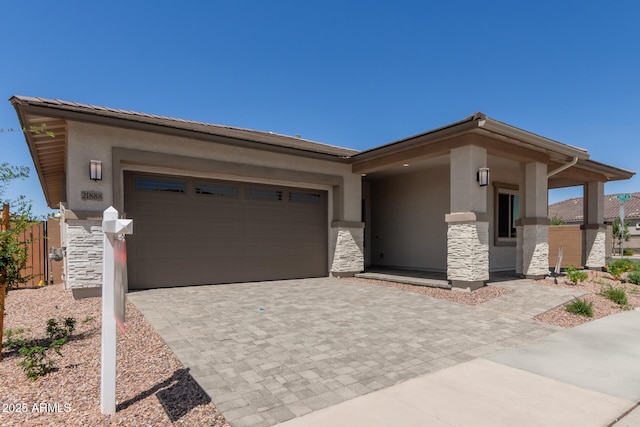 view of front of house with stucco siding, decorative driveway, a garage, and stone siding