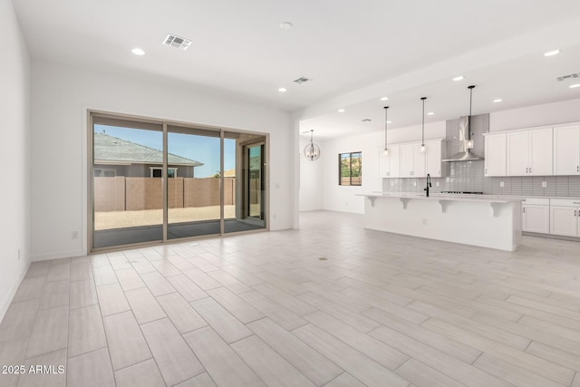 unfurnished living room featuring visible vents, recessed lighting, and light wood finished floors