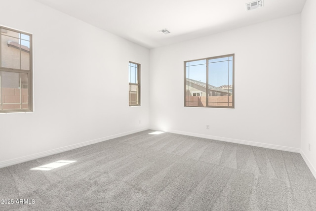 unfurnished room featuring baseboards, visible vents, and carpet flooring