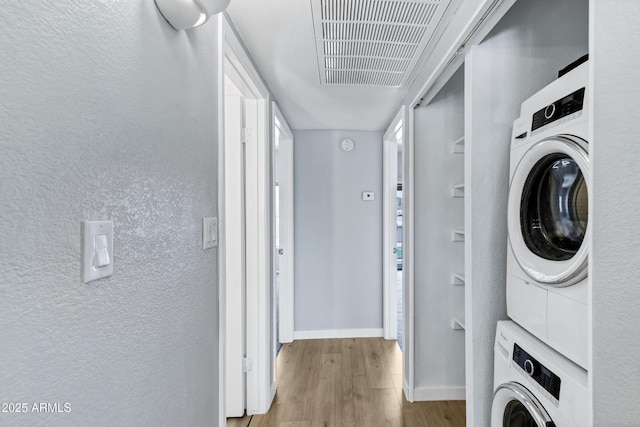 1017 E Maryland Ave Unit 236, Phoenix, AZ 85014 - washroom with visible vents, stacked washer and clothes dryer, a textured wall, and wood finished floors