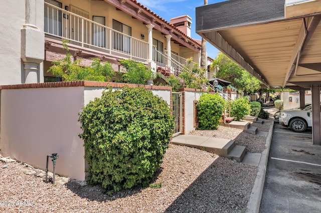 1017 E Maryland Ave Unit 236, Phoenix, AZ 85014 - exterior space with stucco siding, a tiled roof, fence, and a gate