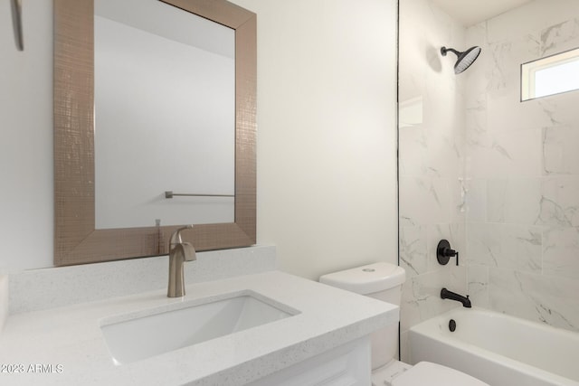 full bathroom featuring vanity, tiled shower / bath, and toilet