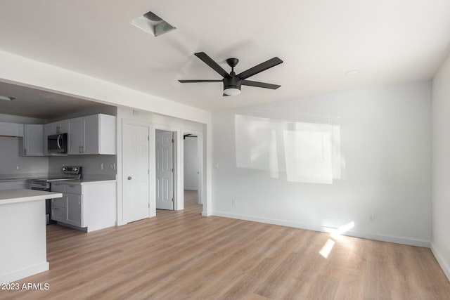 kitchen with gray cabinetry, stainless steel appliances, ceiling fan, and light wood-type flooring