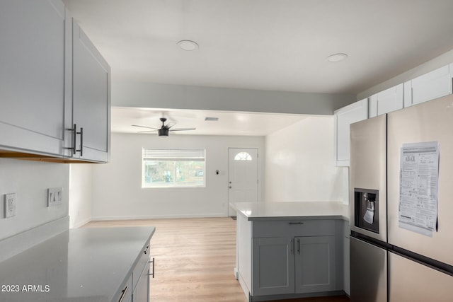 kitchen featuring stainless steel fridge, light hardwood / wood-style floors, kitchen peninsula, gray cabinets, and ceiling fan