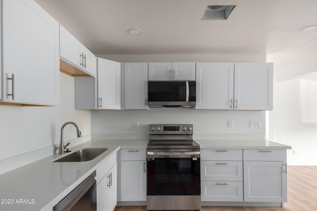 kitchen with white cabinetry, appliances with stainless steel finishes, and sink