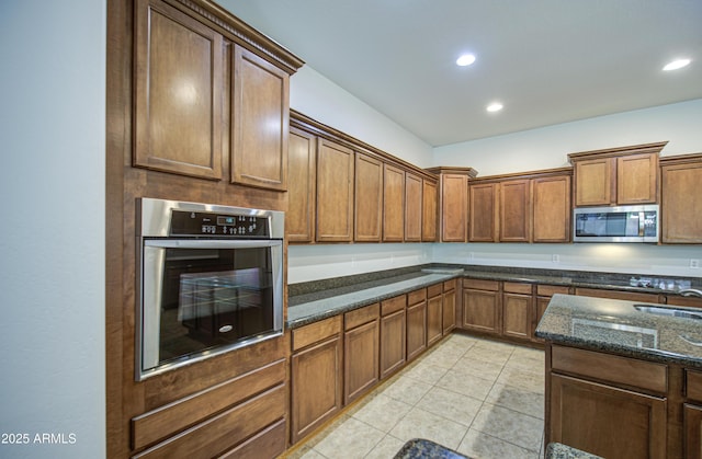 6192 S Claiborne Ave, Gilbert, AZ 85298 - kitchen featuring light tile patterned floors, brown cabinetry, recessed lighting, dark stone countertops, and stainless steel appliances