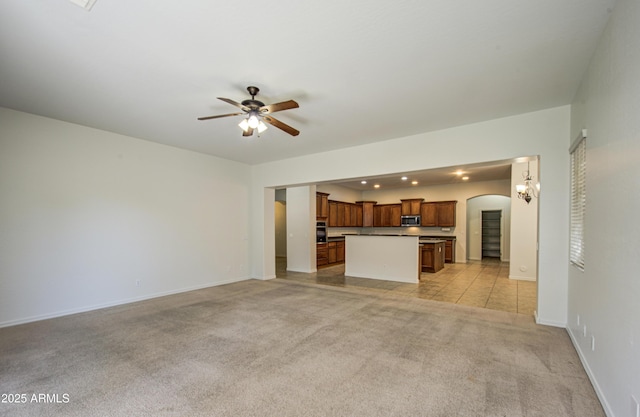 6192 S Claiborne Ave, Gilbert, AZ 85298 - unfurnished living room featuring arched walkways, a ceiling fan, recessed lighting, light carpet, and baseboards