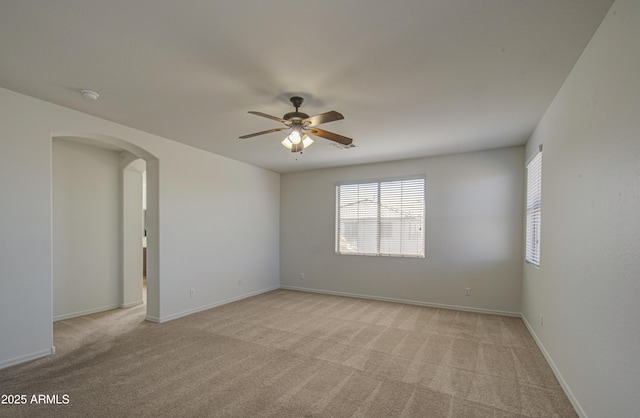 6192 S Claiborne Ave, Gilbert, AZ 85298 - unfurnished room featuring light carpet, ceiling fan, baseboards, and arched walkways