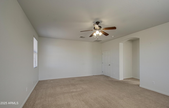 6192 S Claiborne Ave, Gilbert, AZ 85298 - empty room with visible vents, baseboards, arched walkways, a ceiling fan, and light colored carpet