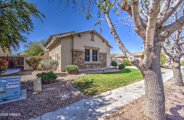 6192 S Claiborne Ave, Gilbert, AZ 85298 - view of front of house featuring fence, stucco siding, stone siding, and a tiled roof