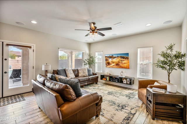 living room with ceiling fan and light wood-type flooring