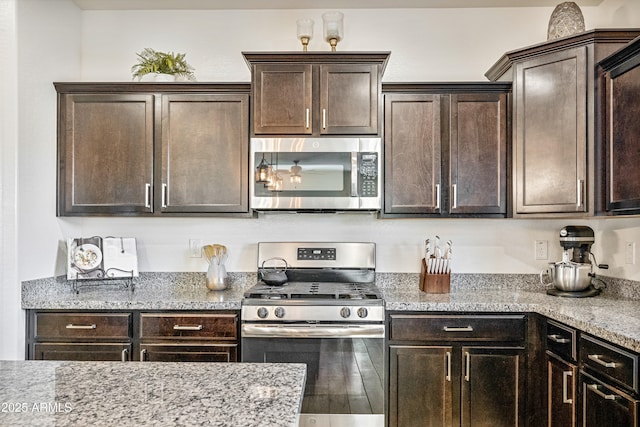 kitchen with light stone counters, appliances with stainless steel finishes, and dark brown cabinets