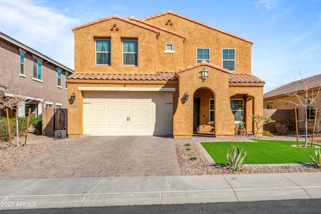 mediterranean / spanish house featuring a garage and a front lawn