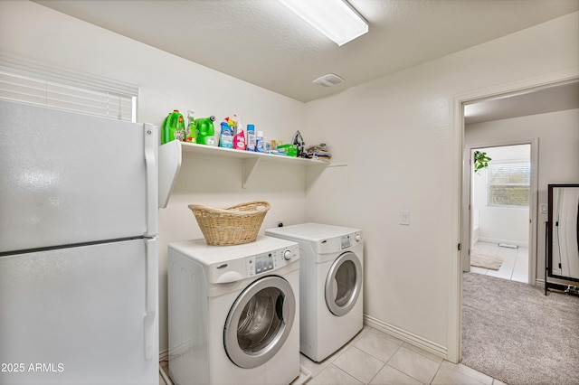 laundry area with washing machine and dryer and light colored carpet