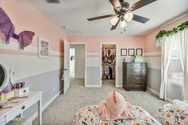 carpeted bedroom featuring a walk in closet, ceiling fan, and a closet