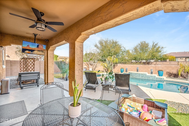 view of patio featuring a fenced in pool and ceiling fan