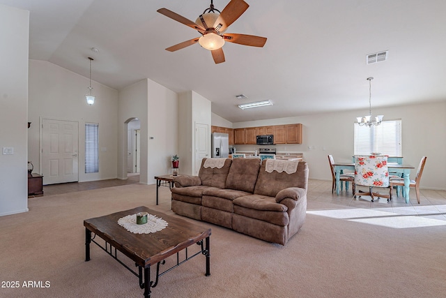 living room with light colored carpet, lofted ceiling, and ceiling fan with notable chandelier