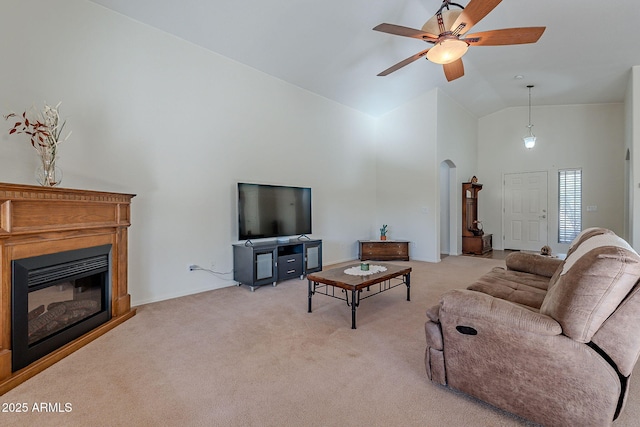 carpeted living room with ceiling fan and high vaulted ceiling