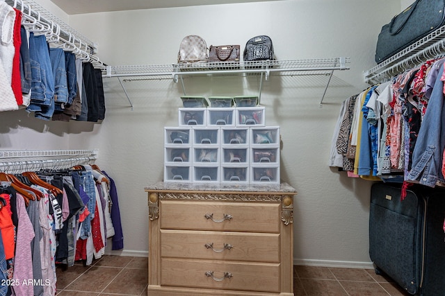 spacious closet featuring dark tile patterned flooring