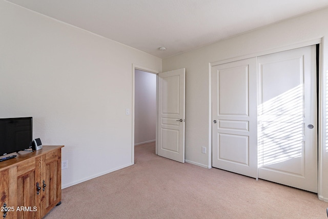 bedroom with light colored carpet and a closet