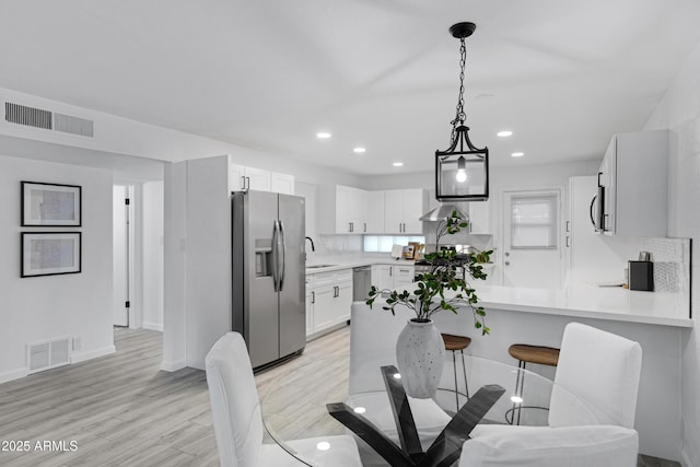 dining space with sink and light hardwood / wood-style flooring