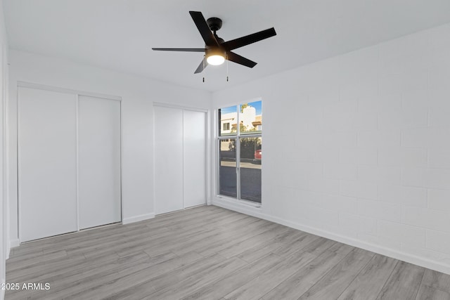 empty room with ceiling fan and light hardwood / wood-style flooring