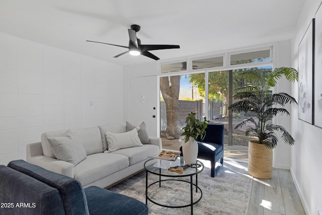 living room with ceiling fan and light hardwood / wood-style flooring