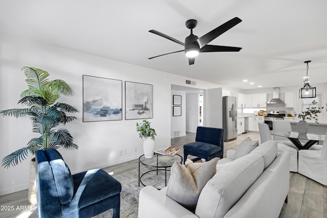 living room with light hardwood / wood-style floors and ceiling fan