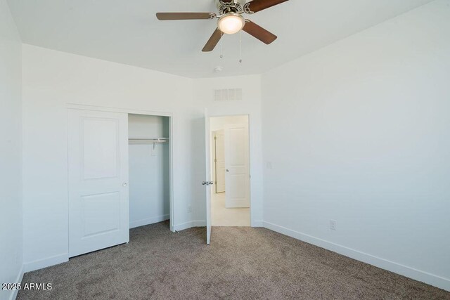 unfurnished bedroom with light carpet, ceiling fan, and a closet