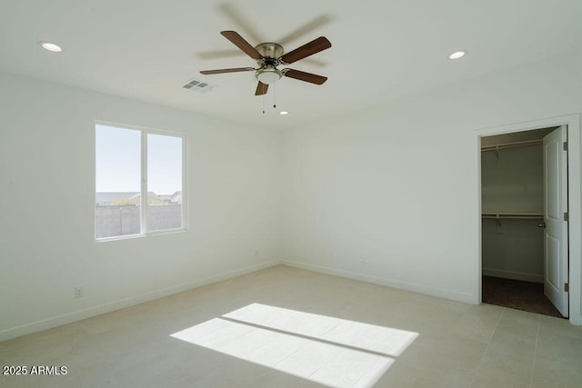 unfurnished bedroom with a spacious closet, ceiling fan, and a closet