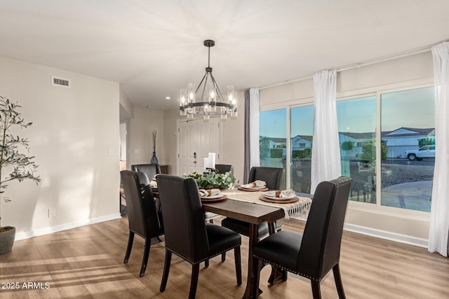 12866 W Orange Dr, Litchfield Park, AZ 85340 - dining room with a chandelier, light wood finished floors, and baseboards