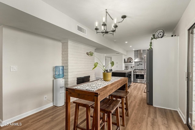 12866 W Orange Dr, Litchfield Park, AZ 85340 - dining space featuring a chandelier, wood finished floors, a fireplace, baseboards, and recessed lighting