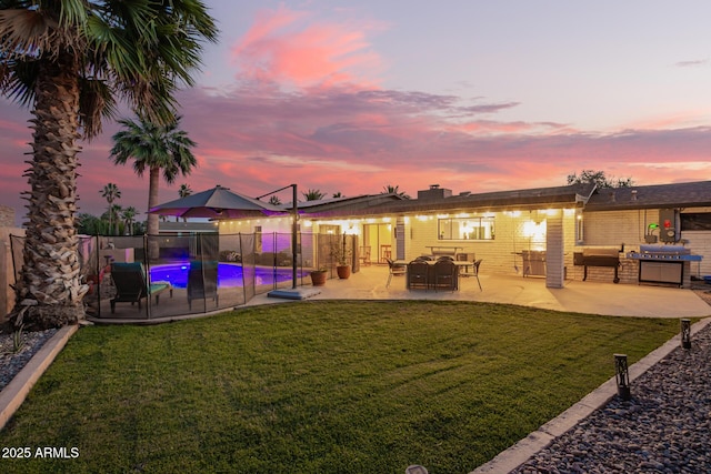 12866 W Orange Dr, Litchfield Park, AZ 85340 - back of house at dusk with a patio area and brick siding