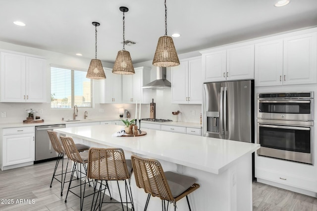 kitchen with a kitchen island, white cabinets, and appliances with stainless steel finishes