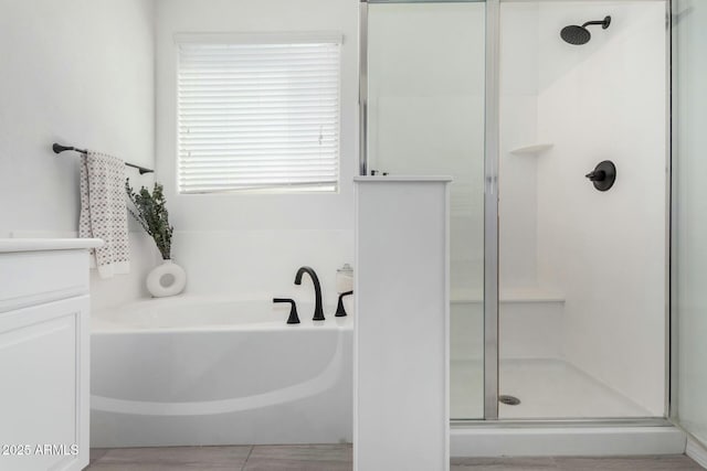 bathroom with vanity and shower with separate bathtub