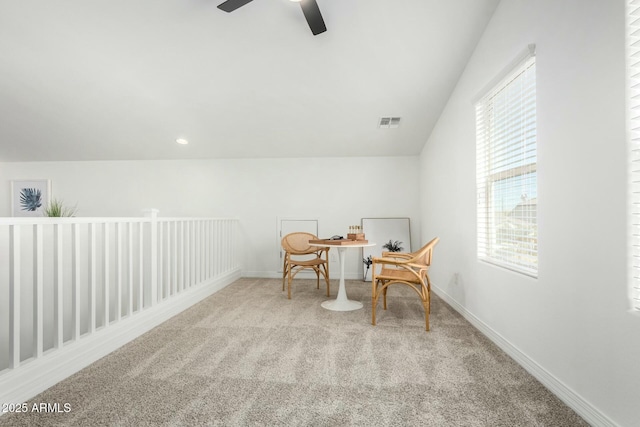 living area with ceiling fan, lofted ceiling, and light carpet