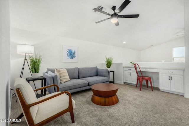 living room with built in desk, ceiling fan, light carpet, and lofted ceiling