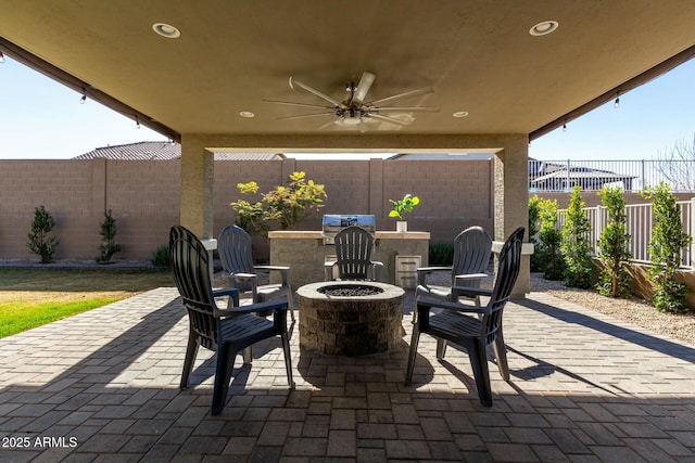 view of patio with ceiling fan, grilling area, and a fire pit