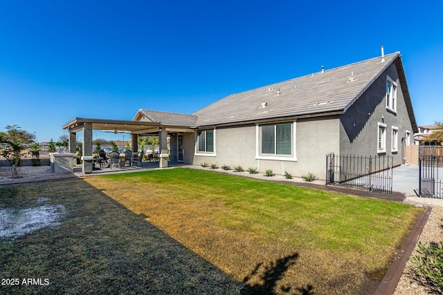 rear view of property with a patio area, a lawn, and ceiling fan